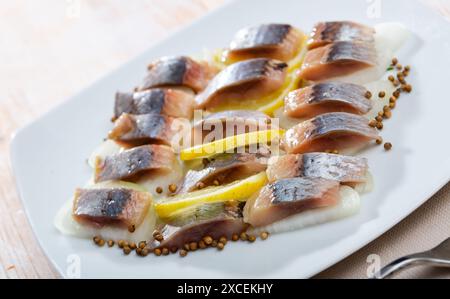 Marinierter Hering mit geschnittenen Zwiebeln und Zitrone Stockfoto