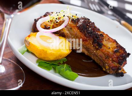 Gebratene Schweinerippchen in Schokoladensoße mit gebackenen Kartoffeln Stockfoto