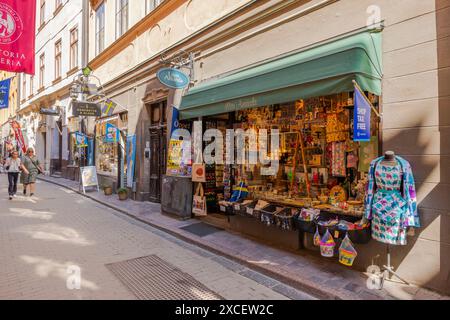 Wunderschöner Blick auf eine charmante Straße in Gamla Stan, Stockholm, mit malerischen Geschäften, farbenfrohen Geschäften und Leuten, die an einem sonnigen Tag spazieren gehen. Schweden. Stockfoto