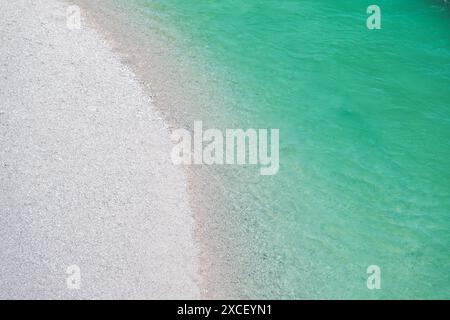 Ein Blick von oben auf einen unberührten Strand mit weißem Sand und klarem türkisfarbenem Wasser. Fluss Soca, Slowenien. Stockfoto