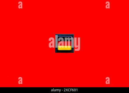 Deutsche Flagge auf einem einfachen quadratischen Knopf auf einem durchgehenden roten Hintergrund. Deutschkurse Schulzeichen, Geschichts- und Kulturpädagogik und Stockfoto
