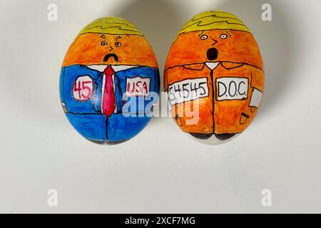 Cartoonzeichnungen auf Eiern zeigen den 45. "Eier"-Präsidenten als politischen Kandidaten und Sträfling in orangefarbenem Jumpsuit vor weißem Hintergrund. Stockfoto