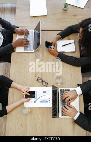 Geschäftskollegen arbeiten gemeinsam an Laptops und Smartphones Stockfoto