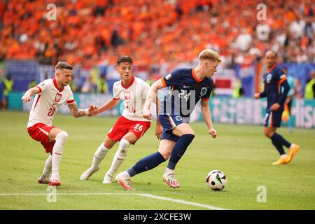Hamburg, Deutschland. Juni 2024. Jerdy Schouten (R) aus den Niederlanden, Bartosz Slisz (L) und Kacper Urba?ski (2. L) aus Polen im Volksparkstadion im Rahmen des Gruppenspiels der UEFA EURO 2024 in der Gruppe D zwischen Polen und den Niederlanden. (Endpunktzahl; Polen 1:2 Niederlande) Credit: SOPA Images Limited/Alamy Live News Stockfoto