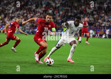 Gelsenkirchen. Juni 2024. Dusan Tadic (L) von Serbien streitet mit Marc Guehi von England während des Gruppenspiels der UEFA Euro 2024 in Gelsenkirchen, Deutschland am 16. Juni 2024. Quelle: Zhang Fan/Xinhua/Alamy Live News Stockfoto