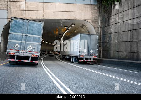 Zwei große Lkw-Sattelzugmaschinen mit Industrieträger und verlängerter Fahrerkabine für LKW-Fahrer, die Ladung in Kühltruhen transportieren Auflieger mit i Stockfoto