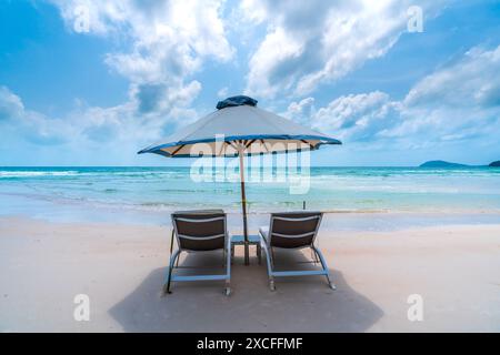 Sonnenliegen unter tropischen Palmen am Strand auf Phu Quoc Insel, Vietnam. Das Lächeln des Strands Stockfoto