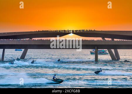 Künstler, die Jetski und Flyboard auf dem Wasser in der Stadt bei Sonnenuntergang aufführen, ziehen viele Touristen in Phu Quoc, Vietnam, an Stockfoto