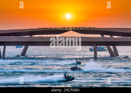 Künstler, die Jetski und Flyboard auf dem Wasser in der Stadt bei Sonnenuntergang aufführen, ziehen viele Touristen in Phu Quoc, Vietnam, an Stockfoto