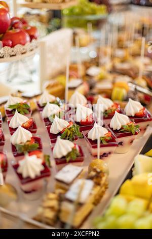 Leckere Erdbeerdesserts mit Creme auf einem eleganten Buffettisch, perfekt für Empfänge Stockfoto