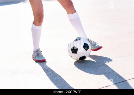 Füße eines Fußballspielers, der mit Fußball spielt Stockfoto
