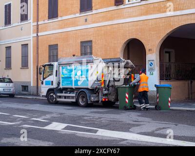 Cremona, Italien - 10. Juni 2024 kommunaler Müllsammler in Uniform, der Mülltonnen auf der Straße mit einem Müllwagen entleert Stockfoto