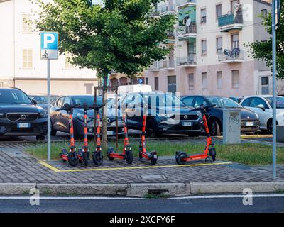 Cremona, Italien - 10. Juni 2024 eine Reihe von Elektrorollern steht auf dem Bürgersteig in einem Stadtzentrum, die gemietet werden können Stockfoto