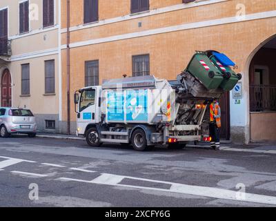 Cremona, Italien - 10. Juni 2024 Müllwagen sammelt Mülltonnen mit einem Sanitärangehörigen, der den Betrieb in einem Wohngebiet kontrolliert Stockfoto