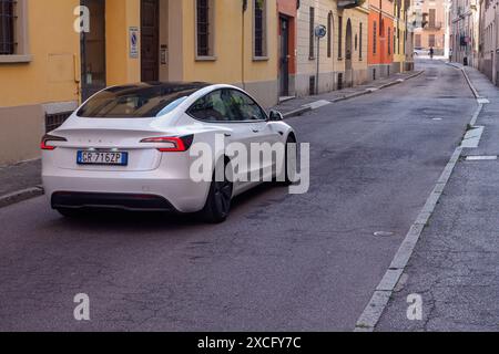 Cremona, Italien - 10. Juni 2024 der White tesla Model 3 parkt auf einer schmalen Straße in einer europäischen Stadt und zeigt elektrischen Transport in einem städtischen e Stockfoto