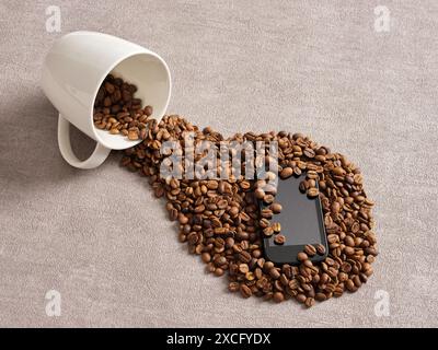 Kaffee auf dem Smartphone verschüttet. Unfälle und Katastrophen. Flüssigkeitshalterung und Haltbarkeit des Smartphones. Kaffeebohnen, die aus der Tasse auf das Smartphone auf ta verschüttet werden Stockfoto