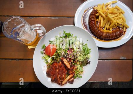 Salat mit putenstreifen und Currywurst mit Pommes frites in einer Gartenwithe, Bayern, Deutschland Stockfoto