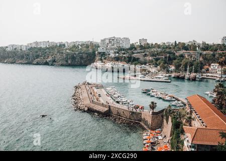 Ein wunderschöner Blick auf den Yachthafen und Strand in der Nähe der Kaleico Altstadt von Antalya in der Türkei an einem sonnigen Tag, mit Menschen, die im blauen Wasser schwimmen. Stockfoto