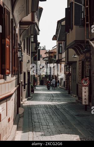 Eine schöne traditionelle Straße in der historischen Altstadt von Antalya in der Türkei an einem sonnigen Tag mit Fenstern, Fensterläden und typischen Gebäuden. Stockfoto