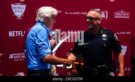 Los Angeles, USA. Juni 2024. Jay Leno schüttelt Mark Stainbrook, Chef der Beverly Hills Police Department, beim Rodeo Drive Concours d'Elegance die Hand. Quelle: Stu Gray/Alamy Live News. Stockfoto