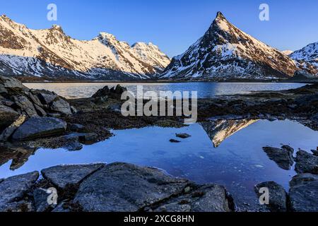 Abendlicht über steilen Bergen an der Küste, Winter, Flakstadoya, Lofoten, Norwegen, Europa Stockfoto