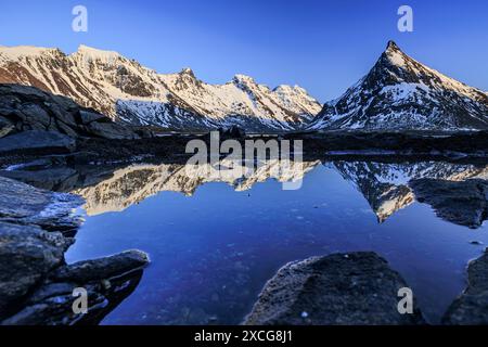 Abendlicht über steilen Bergen an der Küste, Winter, Flakstadoya, Lofoten, Norwegen, Europa Stockfoto