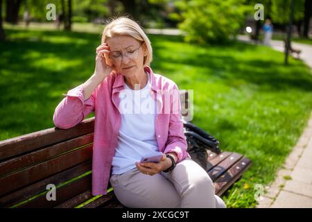 Porträt der Reifen Frau im Park. Sie macht sich Sorgen. Stockfoto