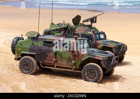 Gijon, Spanien - 24. Mai 2024: Militärische gepanzerte Fahrzeuge an der Sandküste, die mit Panzerabwehrwaffen und einem Maschinengewehrhalter ausgestattet sind Stockfoto