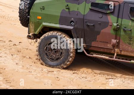 Gijon, Spanien - 24. Mai 2024: Nahaufnahme eines Militärfahrzeugrads an einem Sandstrand Stockfoto