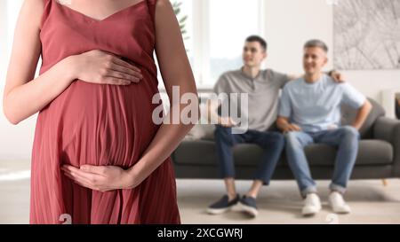 Schwangere Leihmutter und glückliches Schwulenpaar zu Hause, selektiver Fokus Stockfoto