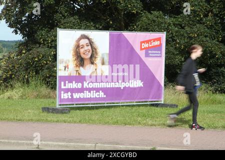 Eine junge Frau geht am Montag 17.06.2024 in der Hansestadt Demmin Landkreis Mecklenburgische Seenplatte an einem Großplakat der Partei die linke vorbei, dass den weiblichen Führungsanspruch der Linkspartei in der Kommunalpolitik unterstreicht. Die Partei hat bei den zurückliegenden Kommunalwahlen und dem letzten Wahlgang zur Europawahl erheblich an Stimmen eingebüßt. Ein Grund dafür war u.a. die Gründung der Partei Bündnis Sahra Wagenknecht Vernunft und Gerechtigkeit die besonders im Nordosten zahlreiche Wählerstimmen auf sich vereinen konnte. Darunter insbesondere im Landkreis Mecklenburgisc Stockfoto