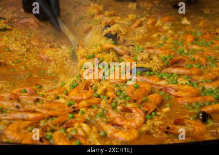 Paella vorbereiten, Borough Market, Bermondsey, Southwark, London, UK - Paella; spanische Delikatesse; Garnelen; Erbsen; Reis; große Fässer mit Paella sind cooke Stockfoto