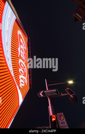 Blick auf das Kings Cross Coke Schild Sydney, beleuchtet in der Abenddämmerung in klarem Abendlicht, Straßenschilder, das KX Hotel und die rote Plakatwand. Stockfoto