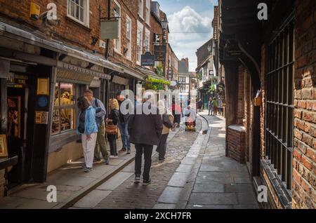 Touristen erkunden die Shambles, die erhaltene mittelalterliche Straße in York, North Yorkshire, England. Stockfoto