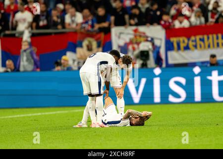 Gelsenkirchen, Deutschland. Juni 2024. Marc Guehi (6) und John Stones (5) überprüfen Kieran Trippier (12) aus England während des Spiels der UEFA Euro 2024 in der Gruppe C zwischen Serbien und England in der Veltins-Arena in Gelsenkirchen. Quelle: Gonzales Photo/Alamy Live News Stockfoto