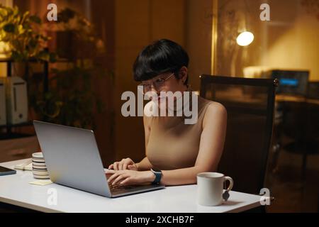 Junge Frau am Laptop im Büro arbeiten Stockfoto