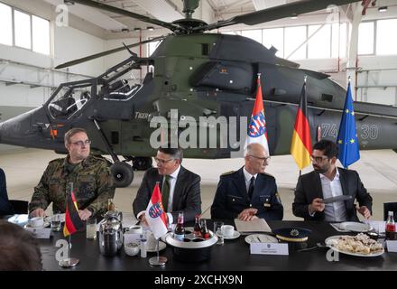 Wiesbaden, Deutschland. Juni 2024. Bernd Stöckmann (l), Kommandeur des Hessischen Landeskommandos der Bundeswehr, sitzt neben Boris Rhein (CDU, 2. V. l.) und Staatspolizeipräsident Robert Schäfer (2. V. R.) in einem Hangar auf dem US-Flugplatz vor einem Kampfhubschrauber Tiger. Das Sicherheitskabinett der hessischen Landesregierung traf sich zu einer externen Kabinettssitzung auf dem U.S. Army Garrison Airfield. Quelle: Boris Roessler/dpa/Alamy Live News Stockfoto