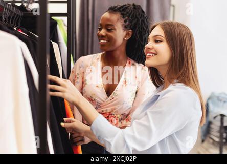 Zwei Frauen, die sich Kleidung auf einem Regal ansehen Stockfoto