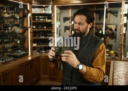 Männlicher Kunde wählt ein neues Fernglas für die Jagd im Waffenladen Stockfoto