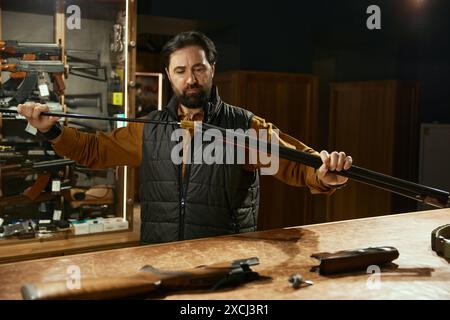 Verkäufer Reinigungspistole mit Ramrod während der Arbeit in der Jagdwerkstatt Stockfoto