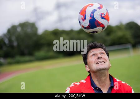 Pulheim, Deutschland. Juni 2024. Fußball: Europameisterschaft: Viktor Pasulko, ehemaliger Fußballnationalspieler der UdSSR, spielt mit einem Fußball auf einem Fußballfeld. Pasulko (63) ist der einzige Spieler, der in Deutschland lebt, der aus der Sowjetunion (UdSSR) das Europameisterfinale 1988 in München erreichte. Quelle: Rolf Vennenbernd/dpa/Alamy Live News Stockfoto