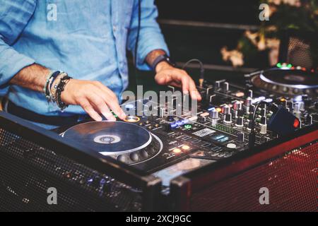 Ein DJ mischt Musik auf professioneller DJ-Ausrüstung und präsentiert ein lebendiges und energiegeladenes Nachtleben. Ideal für Musik-, Event- und Unterhaltungsinhalte. Stockfoto
