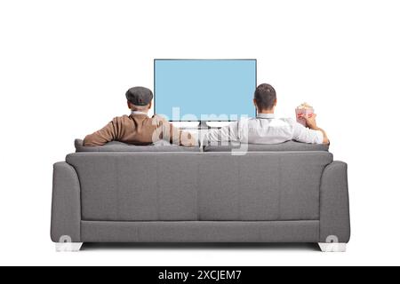 Älterer Vater und Sohn, die Fußball im fernsehen gucken, sitzen auf einem Sofa isoliert auf weißem Hintergrund Stockfoto