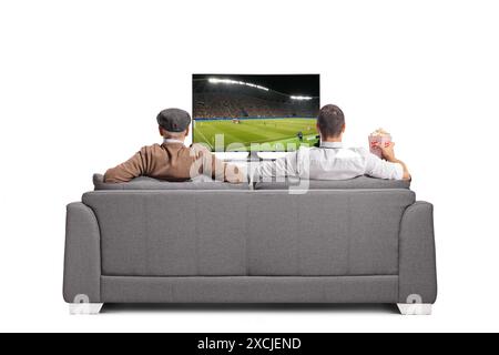 Älterer Vater und Sohn, die fernschauen, sitzen auf einem Sofa isoliert auf weißem Hintergrund Stockfoto