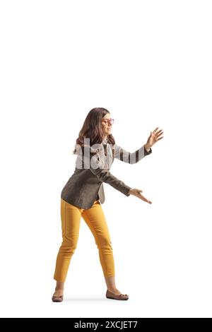 Profilaufnahme einer jungen Frau, die etwas isoliert auf weißem Hintergrund fängt Stockfoto