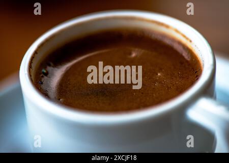 Makrofoto von türkischem Kaffee, das das reiche Aroma, den komplizierten Schaum und die tiefe, dunkle Textur in atemberaubendem Detail einfängt. Stockfoto