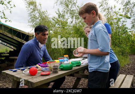 Premierminister Rishi Sunak schließt sich Kindern an, die während eines Besuchs im Great Wood Farm Early Years Centre in Grantham in East Midlands an der Jagd auf Minitiertiere teilnehmen. Bilddatum: Montag, 17. Juni 2024. Stockfoto