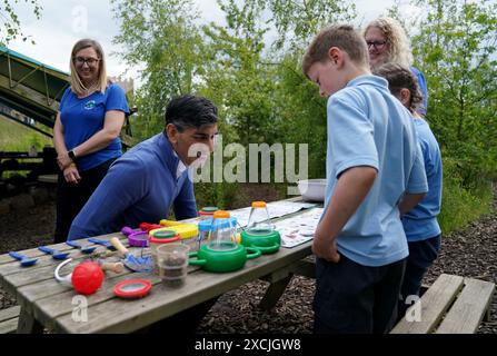 Premierminister Rishi Sunak schließt sich Kindern an, die während eines Besuchs im Great Wood Farm Early Years Centre in Grantham in East Midlands an der Jagd auf Minitiertiere teilnehmen. Bilddatum: Montag, 17. Juni 2024. Stockfoto