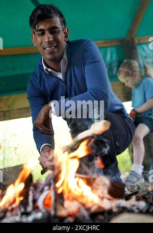 Premierminister Rishi Sunak toast Brot am offenen Feuer während eines Besuchs im Great Wood Farm Early Years Centre in Grantham in East Midlands, während er sich auf dem Wahlkampfpfad der General Election befindet. Bilddatum: Montag, 17. Juni 2024. Stockfoto