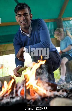 Premierminister Rishi Sunak toast Brot am offenen Feuer während eines Besuchs im Great Wood Farm Early Years Centre in Grantham in East Midlands, während er sich auf dem Wahlkampfpfad der General Election befindet. Bilddatum: Montag, 17. Juni 2024. Stockfoto